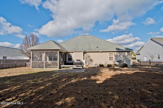 rear view of property with a patio, a lawn, and a sunroom