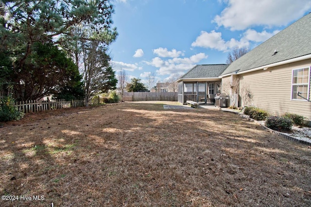 view of yard with a sunroom and a patio