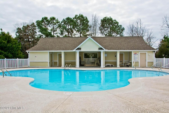 view of swimming pool featuring an outbuilding and a patio