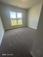 spare room with dark carpet