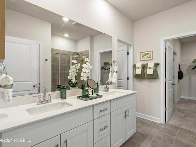 bathroom with a shower with door, vanity, and tile patterned flooring