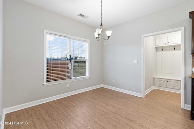 empty room with a chandelier and light hardwood / wood-style flooring