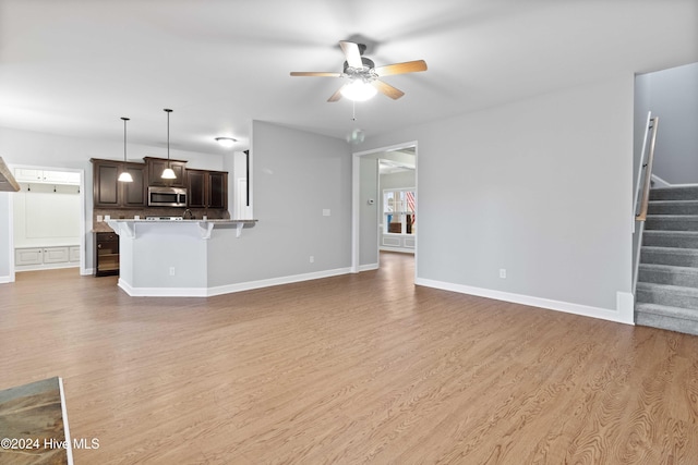 unfurnished living room featuring ceiling fan and hardwood / wood-style flooring