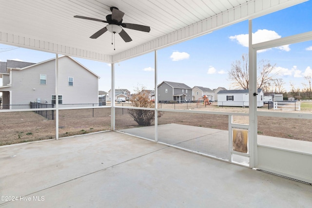 unfurnished sunroom featuring ceiling fan