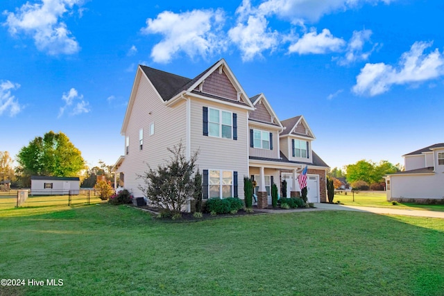 view of front of house featuring covered porch, a garage, and a front yard