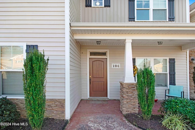 view of exterior entry featuring covered porch