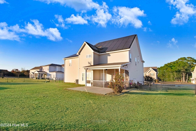 back of house with a sunroom, a yard, and a patio