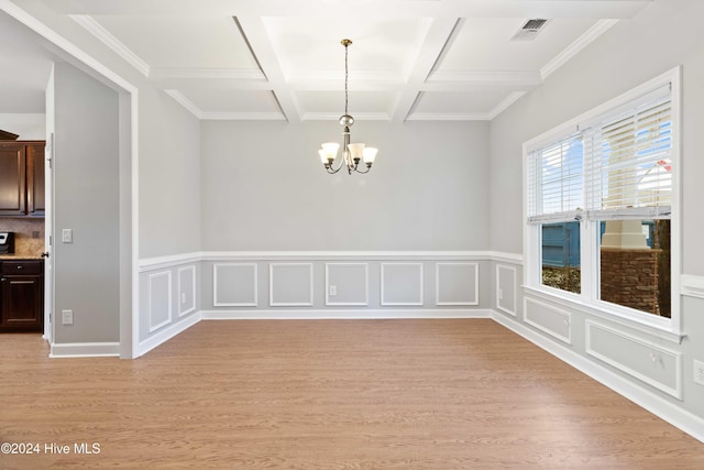 spare room featuring beamed ceiling, a notable chandelier, light wood-type flooring, and coffered ceiling