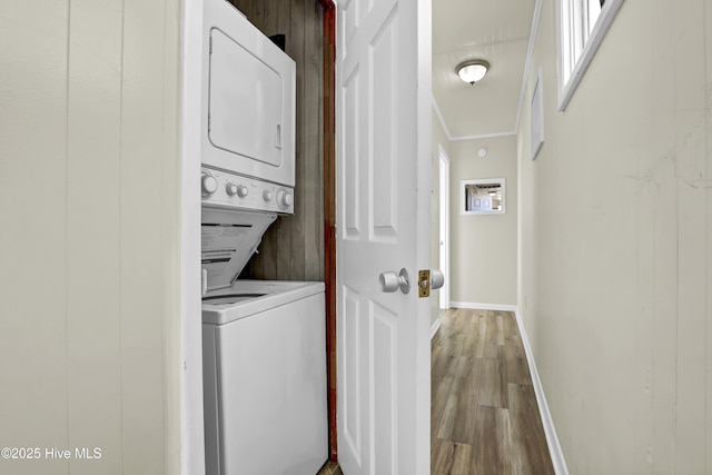 laundry area with stacked washer and dryer and hardwood / wood-style floors