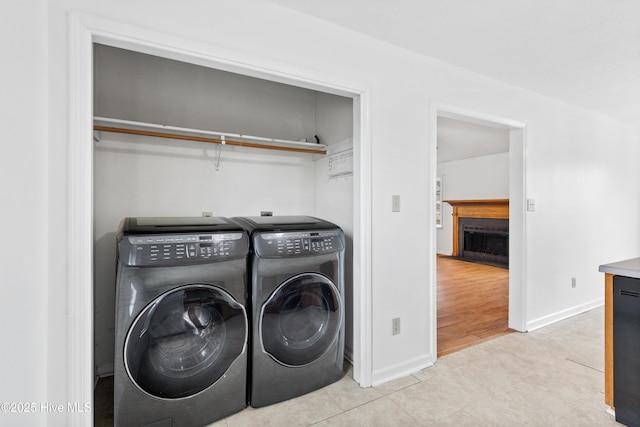 laundry area with washing machine and dryer and light tile patterned floors