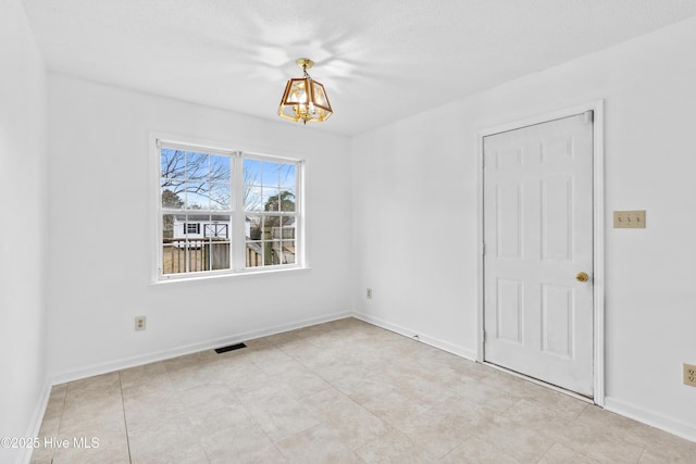 spare room featuring an inviting chandelier