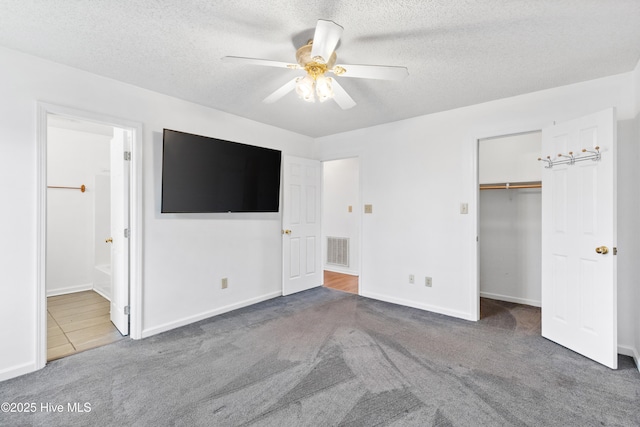 unfurnished bedroom featuring ensuite bathroom, a textured ceiling, ceiling fan, and carpet