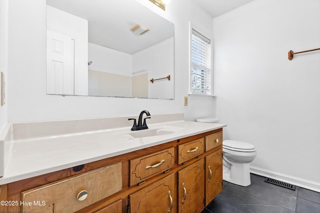 bathroom with toilet, tile patterned floors, and vanity