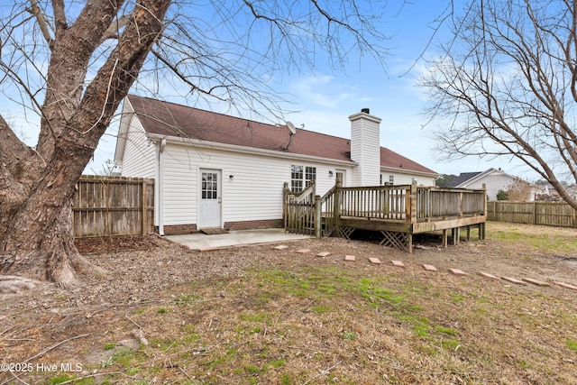 back of house with a wooden deck and a patio area