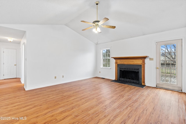 unfurnished living room featuring ceiling fan, a healthy amount of sunlight, light hardwood / wood-style floors, and vaulted ceiling