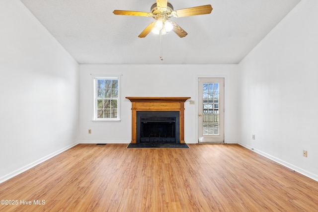 unfurnished living room featuring ceiling fan, plenty of natural light, and light hardwood / wood-style flooring