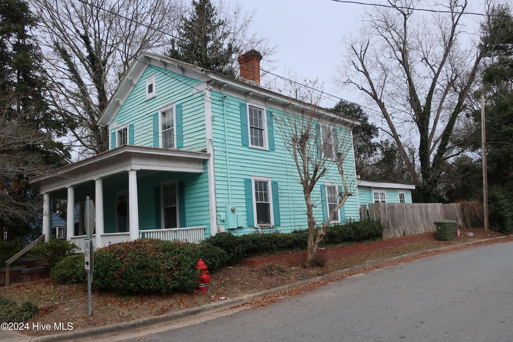 view of side of home featuring covered porch