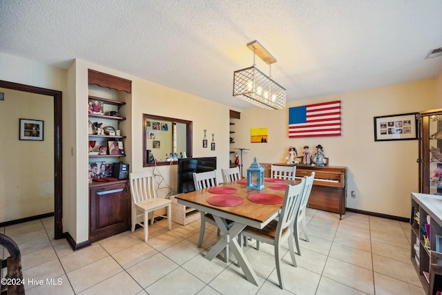 dining space featuring light tile patterned floors and a textured ceiling