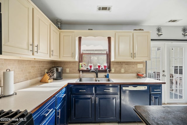 kitchen featuring black dishwasher, sink, backsplash, and blue cabinetry