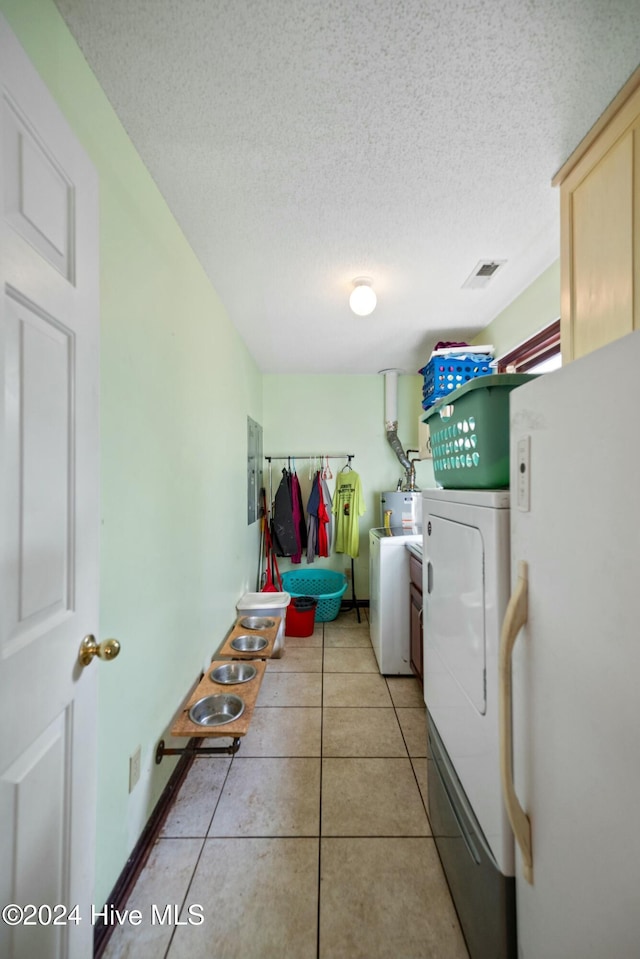 clothes washing area with light tile patterned floors, electric panel, washer and dryer, and a textured ceiling