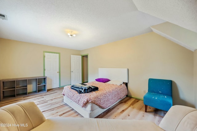 bedroom with hardwood / wood-style flooring and a textured ceiling