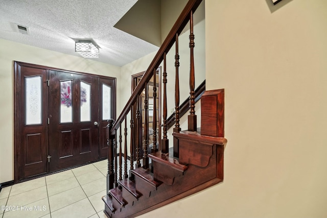 tiled entrance foyer featuring a textured ceiling