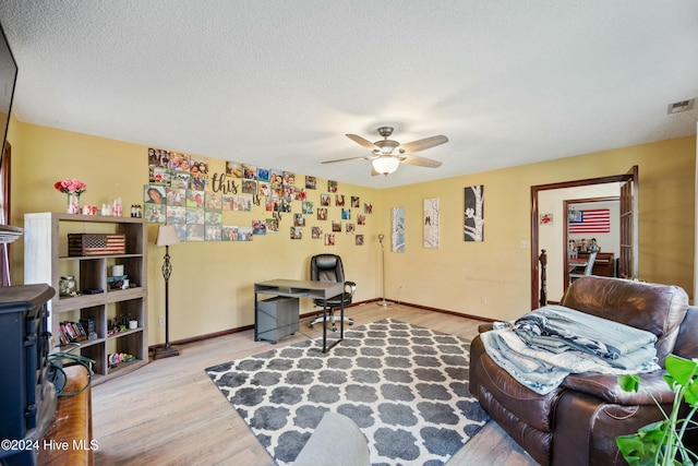 interior space featuring ceiling fan, a textured ceiling, and light wood-type flooring