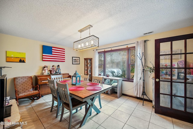 dining space with light tile patterned floors and a textured ceiling