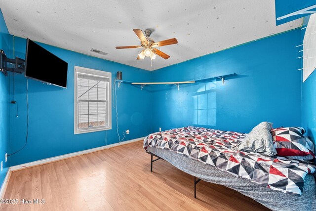 bedroom with ceiling fan, light hardwood / wood-style floors, and a closet