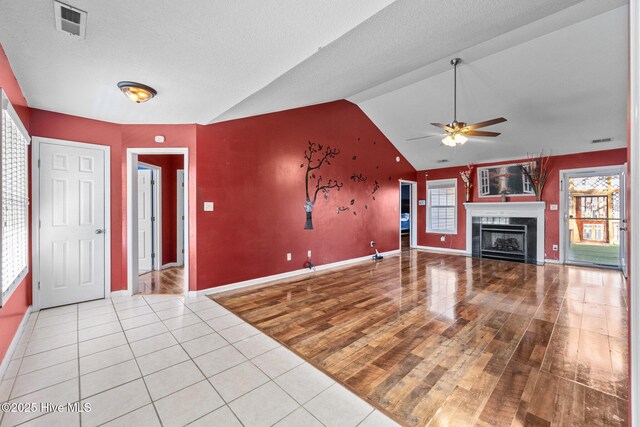 additional living space featuring lofted ceiling, a textured ceiling, light colored carpet, and ceiling fan