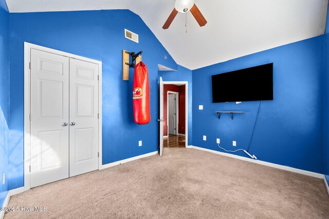 carpeted spare room featuring ceiling fan and vaulted ceiling