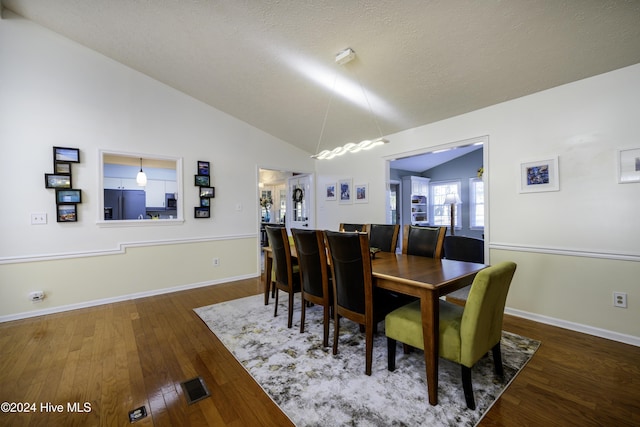 dining space with dark wood-type flooring and lofted ceiling