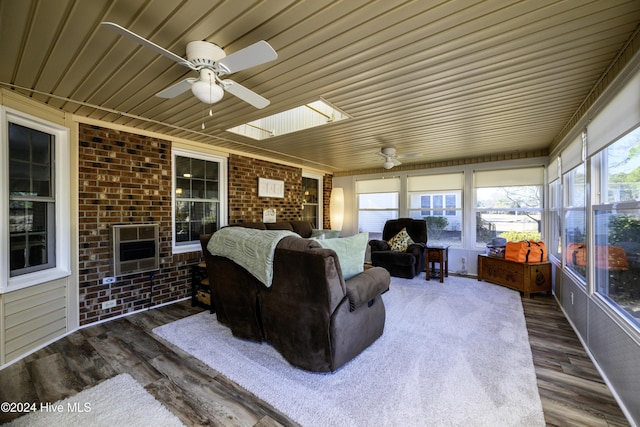 sunroom with ceiling fan, wood ceiling, and a skylight