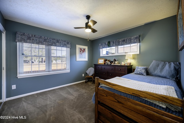 bedroom featuring ceiling fan, a textured ceiling, and dark colored carpet