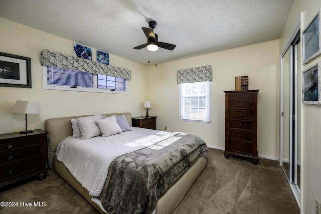 carpeted bedroom featuring ceiling fan, a closet, and a textured ceiling