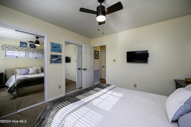 carpeted bedroom featuring ceiling fan and a textured ceiling