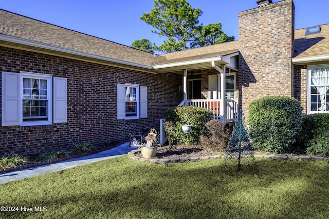 view of exterior entry featuring a yard