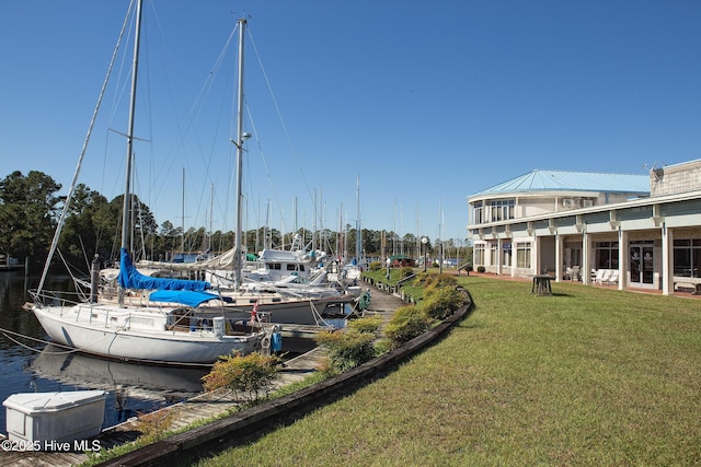 view of dock with a yard and a water view