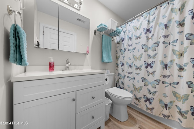 bathroom featuring toilet, hardwood / wood-style floors, vanity, and a shower with shower curtain