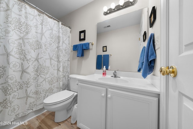 bathroom featuring toilet, vanity, and hardwood / wood-style flooring