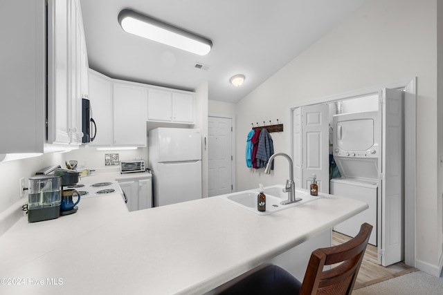 kitchen with white cabinetry, sink, kitchen peninsula, stacked washer / dryer, and white fridge