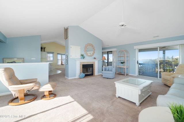 living room with vaulted ceiling, light colored carpet, ceiling fan, and a fireplace