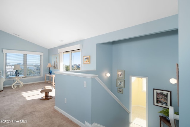 hall with vaulted ceiling and carpet floors