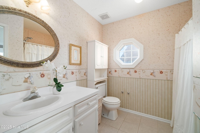 bathroom featuring vanity, tile patterned flooring, and toilet