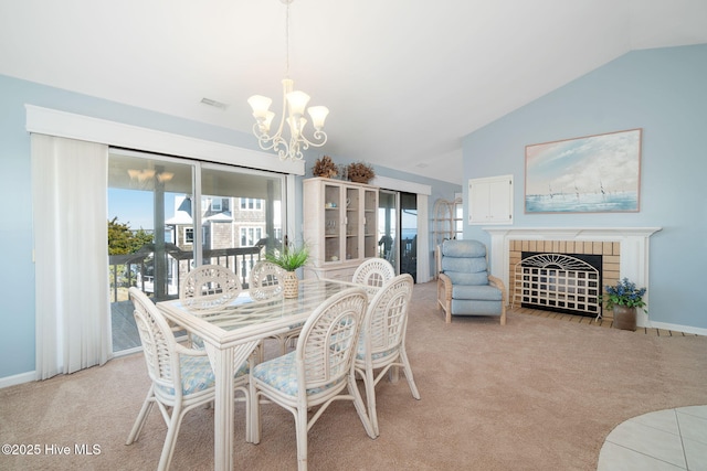 carpeted dining space with an inviting chandelier, lofted ceiling, and a fireplace