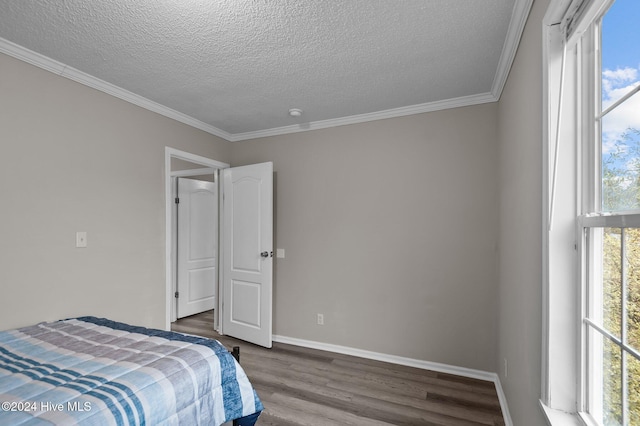 bedroom with a textured ceiling, crown molding, and dark wood-type flooring