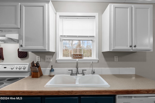 kitchen featuring sink, white cabinetry, and wall chimney range hood