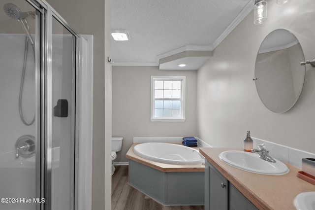 full bathroom featuring wood-type flooring, a textured ceiling, shower with separate bathtub, vanity, and ornamental molding