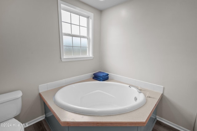 bathroom featuring a tub and toilet