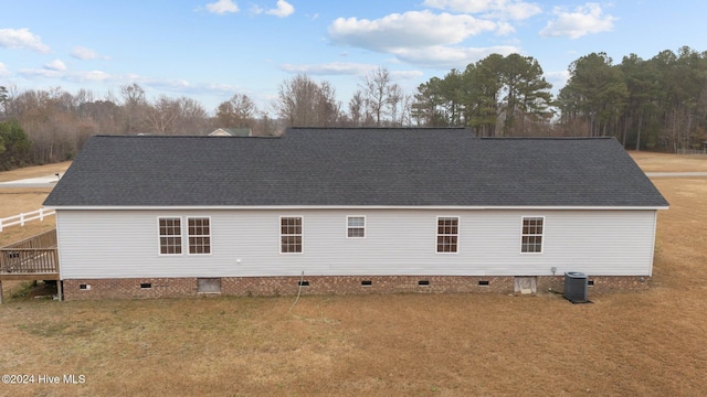 back of house featuring central air condition unit, a lawn, and a wooden deck